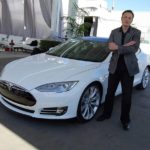 Илон макс на фоне Tesla